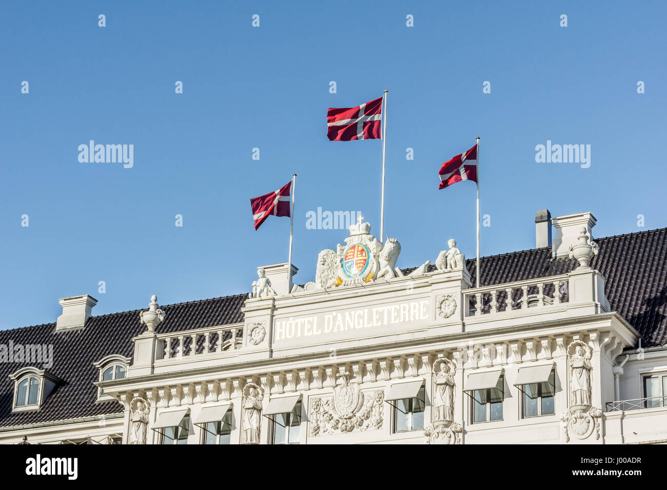Flags flying in the wind on the Facade of the Hotel D´angleterre in Copenhagen, Denmark - April 6, 2017 Stock Photo