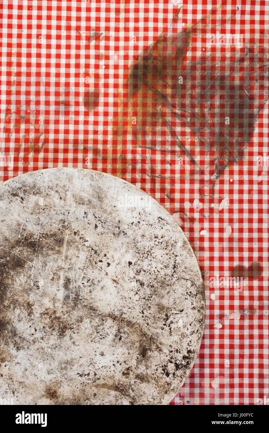 Closeup of a dirty old plate on a stained tablecloth Stock Photo