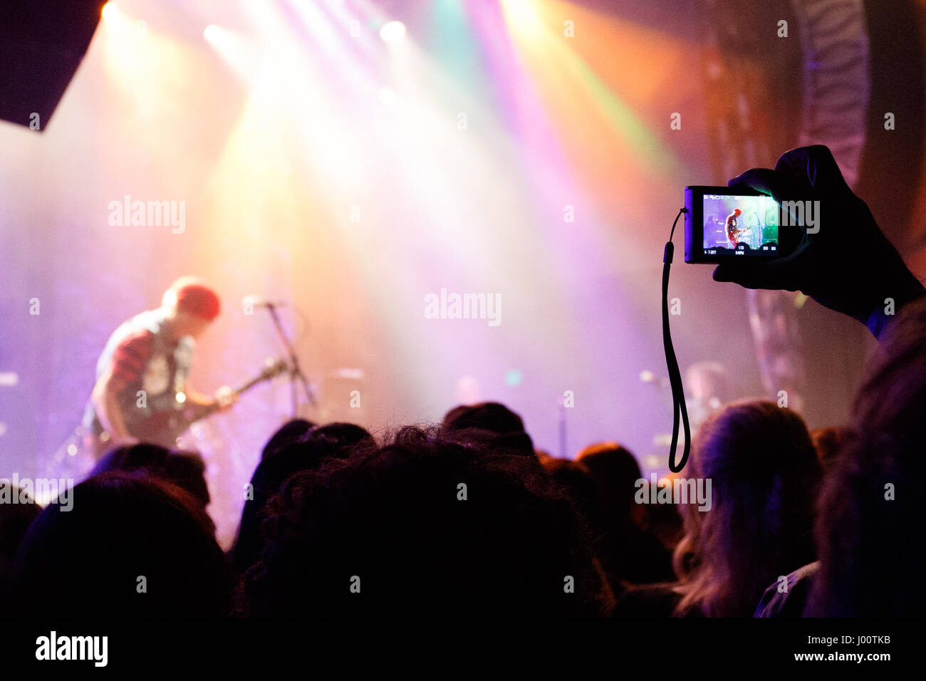 San Diego, California. April 7, 2017. A fan uses their mobile phone to capture an image of Captain Sensible performing with The Damned. Originally formed in 1976 in London, The Damned performed at the House of Blues during their 40th anniversary tour. Stock Photo