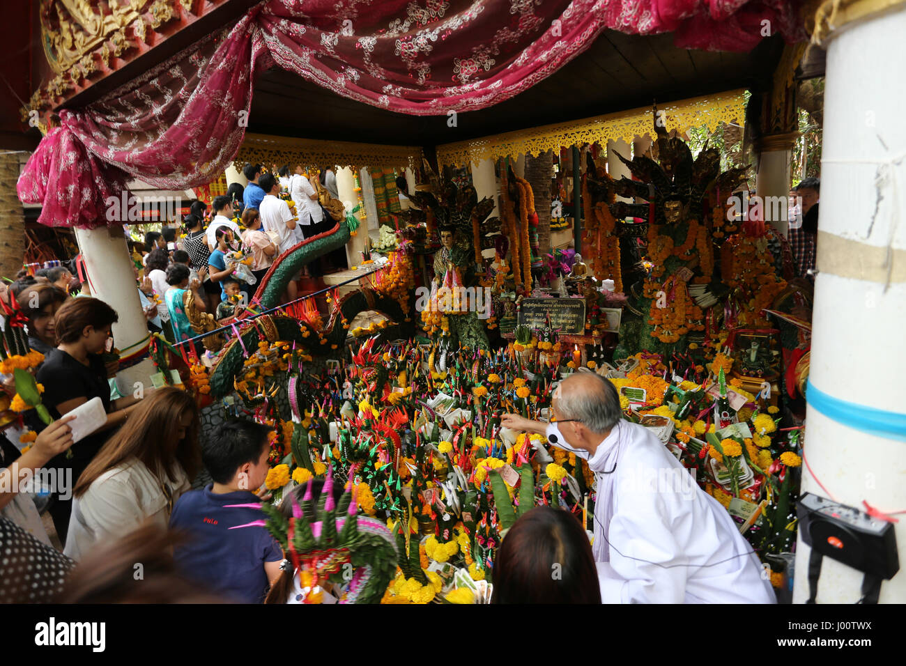 Visitors place offerings at statues of the Naga Serpents in their human form Stock Photo