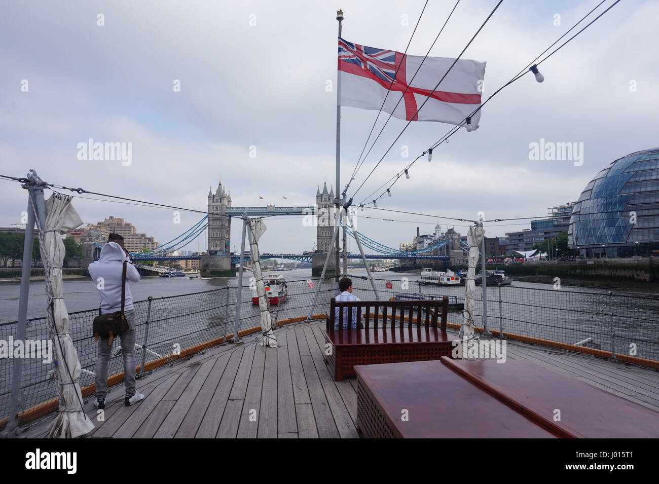 Royal Navy flag flying on the HMS Belfast on the River Thames, London, UK Stock Photo