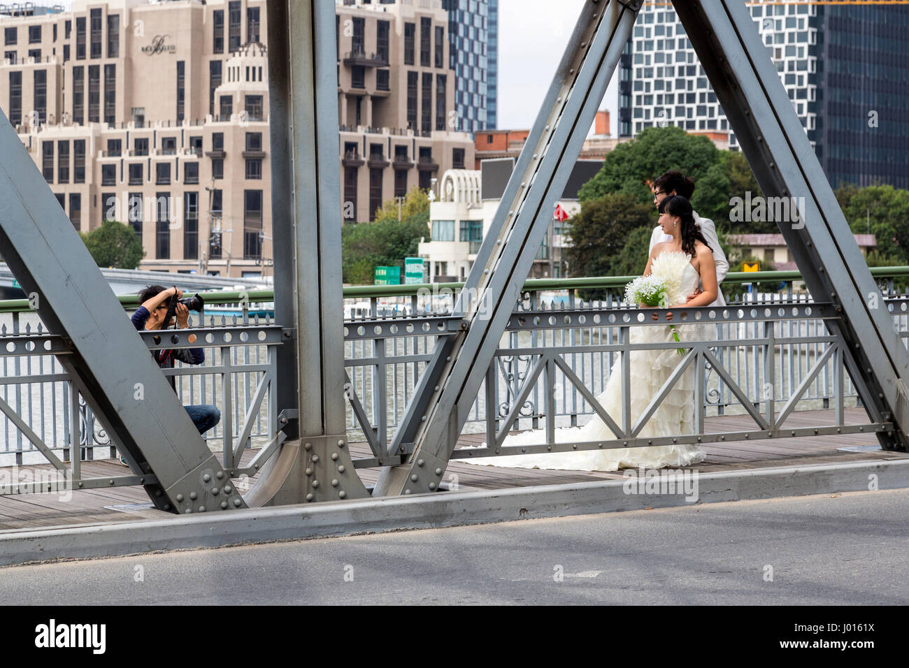 China, Shanghai.  Wedding Photographer Working on the Waibaidu Bridge (Garden Bridge). Stock Photo