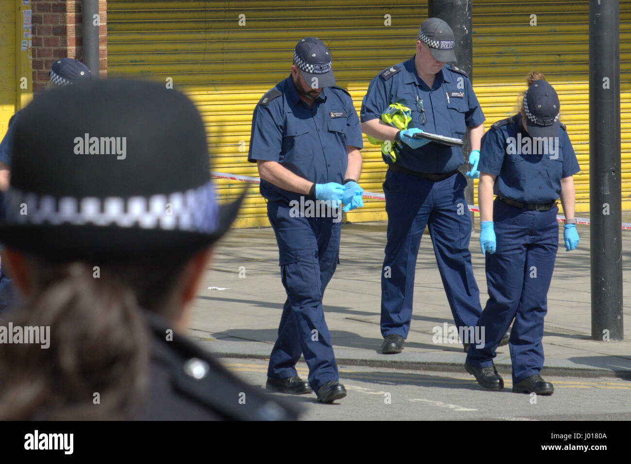 Police searching crime scene for evidence as part of murder inquiry in North Woolwich London Stock Photo