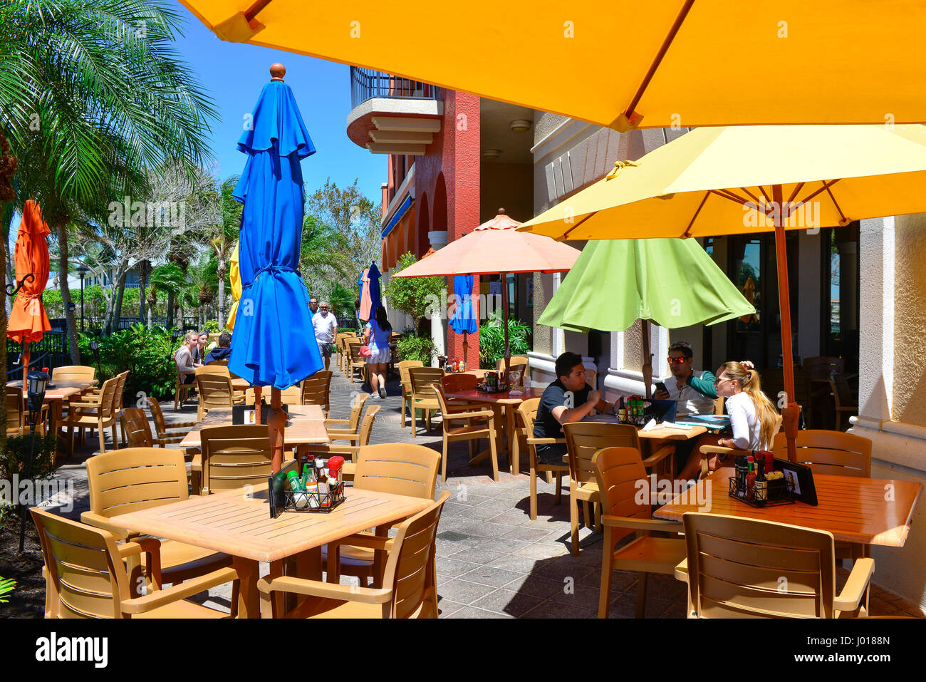 Sunny and colorful patio with diners at the Mango's Dockside Bistro offering waterfront dining