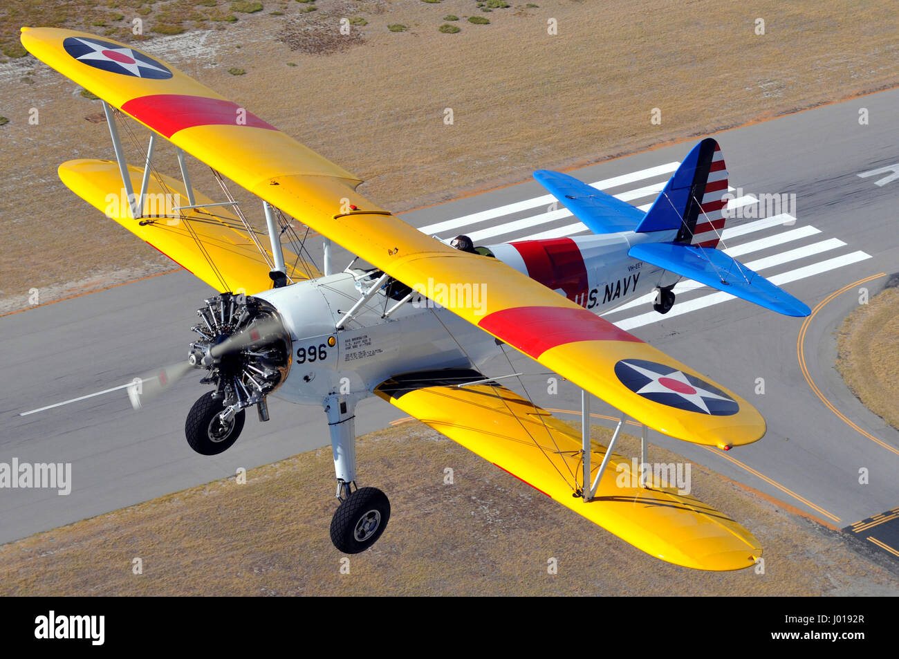 Air to air view of a 1930s era Boeing Stearman aircraft taking off over runway. Western Australia. Stock Photo