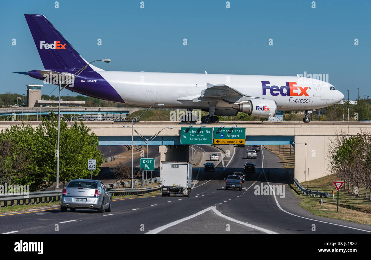 FedEx cargo jet (Airbus A300) on taxiway bridge over airport entrance road at Memphis International Airport (FedEx headquarters) in Memphis, TN, USA. Stock Photo