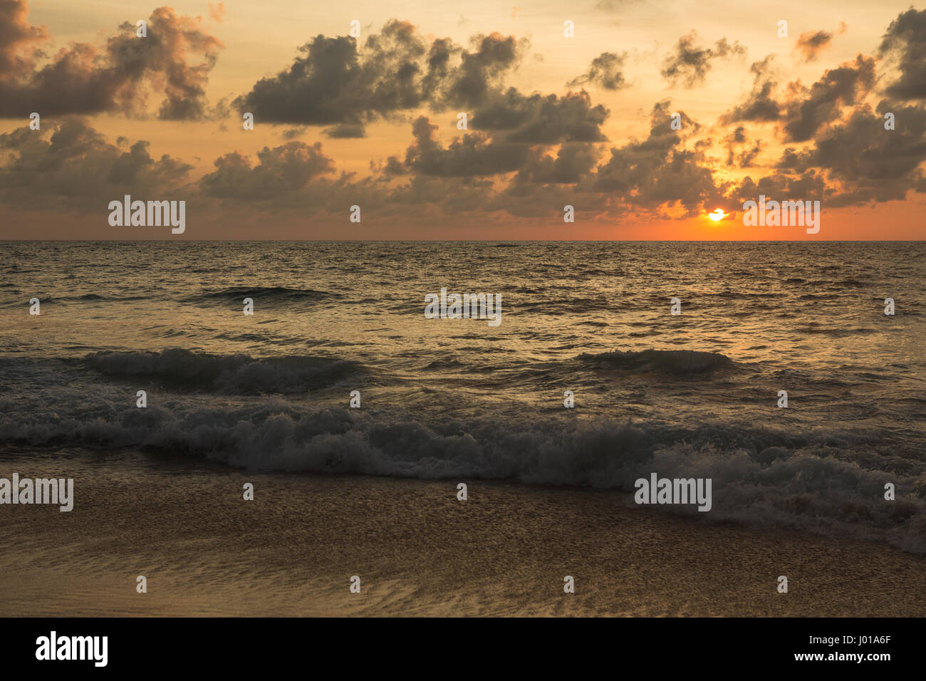 a beautiful sunset in the sea on the beach Stock Photo - Alamy