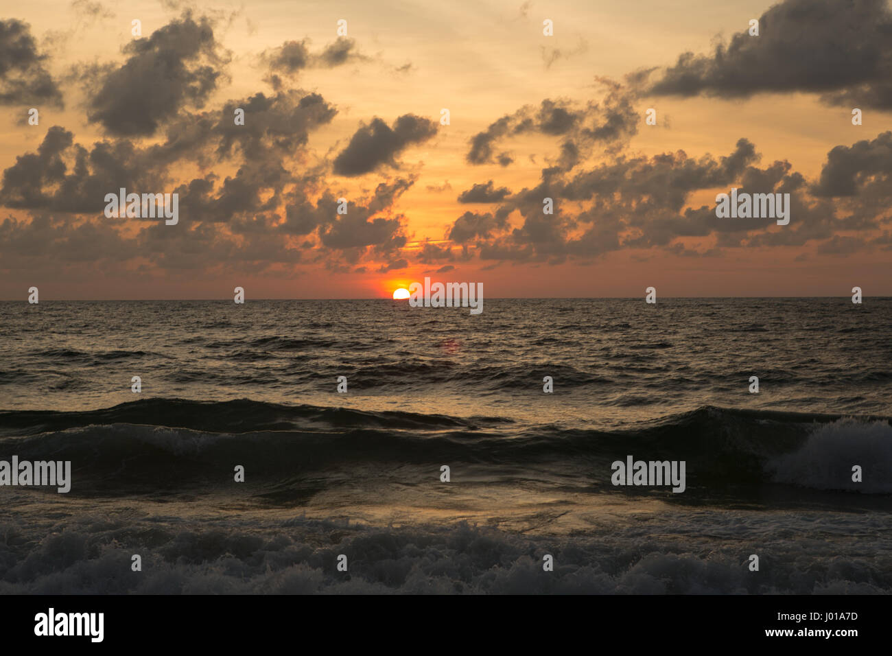 a beautiful sunset in the sea on the beach Stock Photo - Alamy