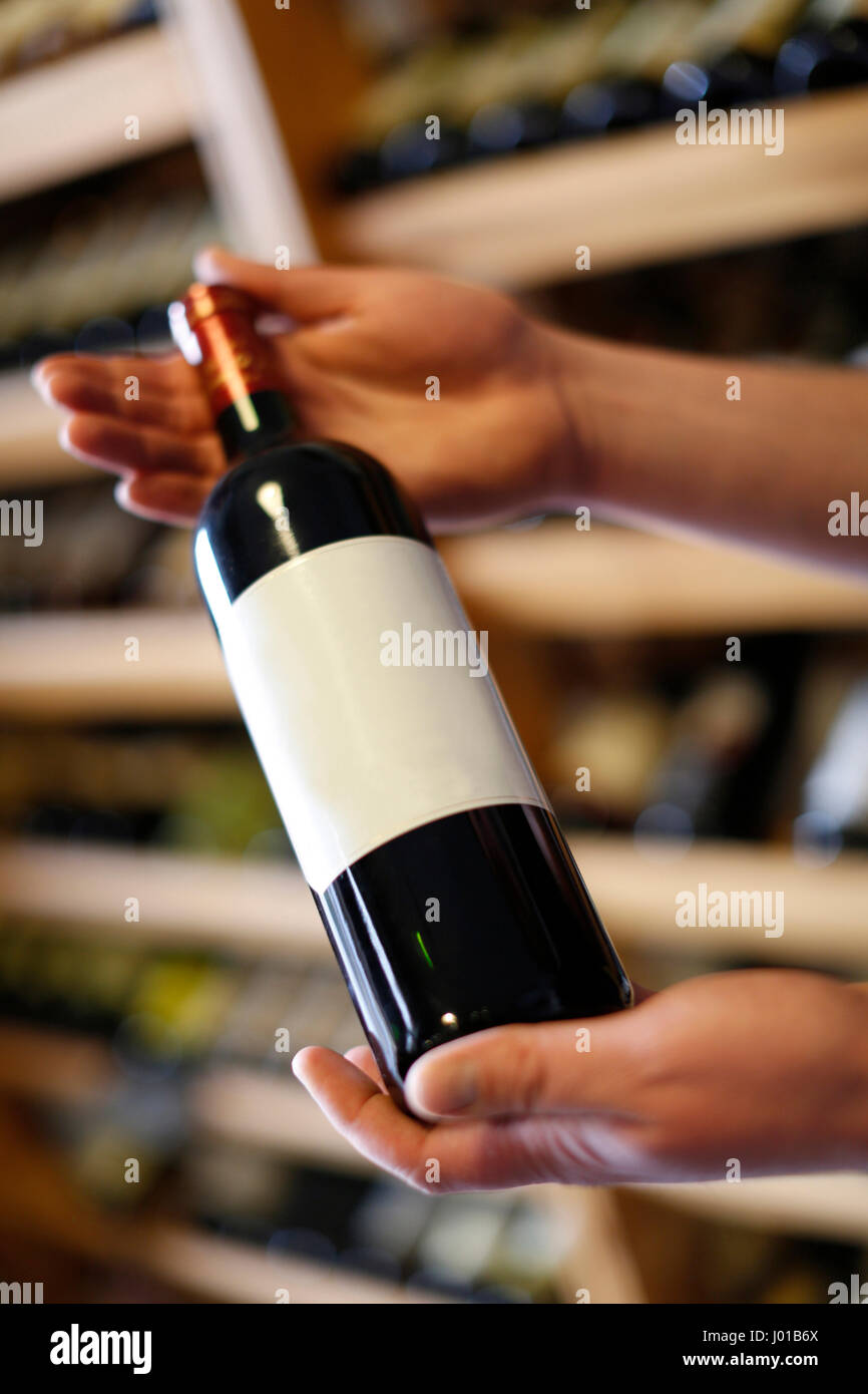 Free label to be able to write their own,hands holding a bottle of wine, wineshop, Carlsbad, Czech Republic Stock Photo