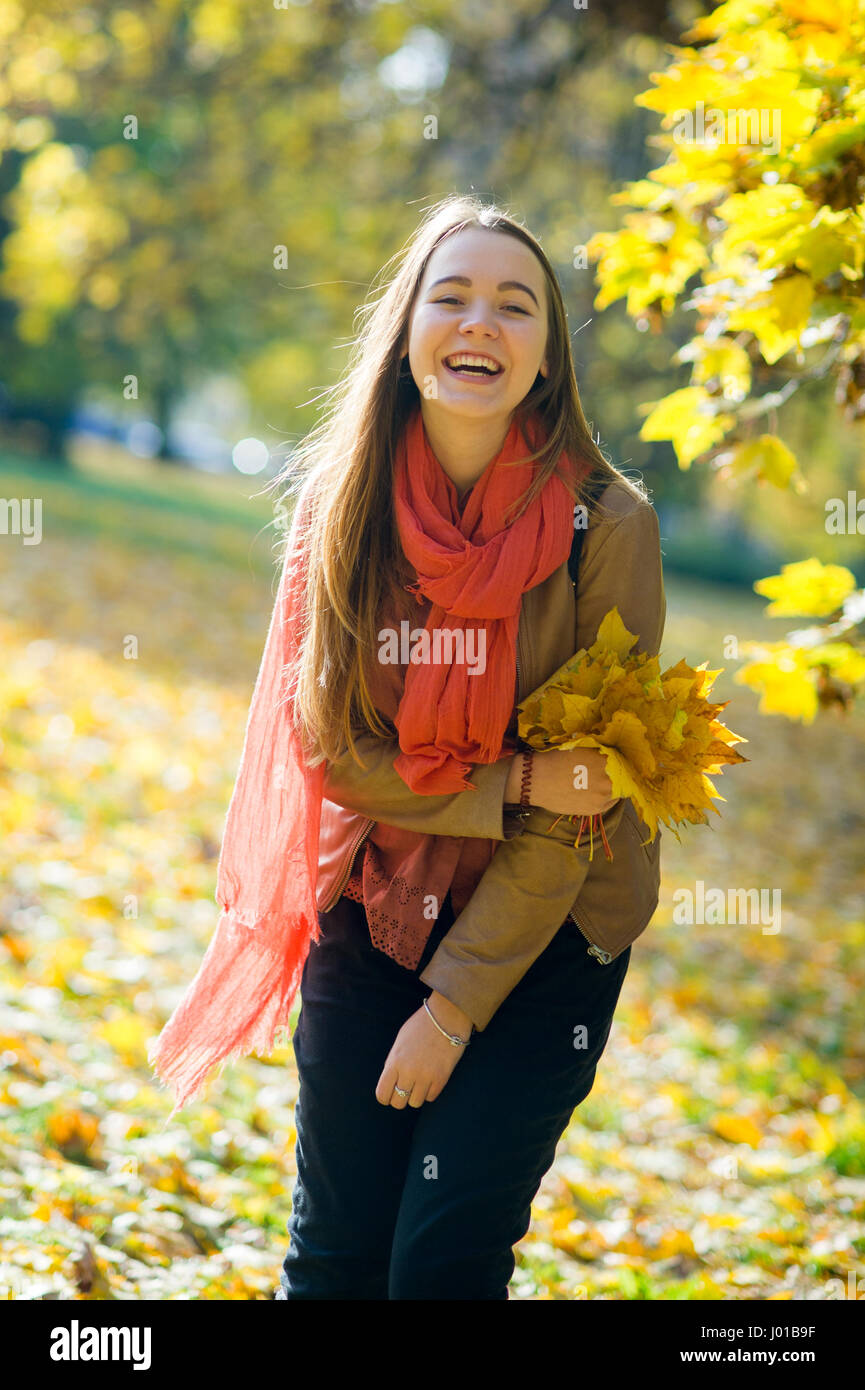 Beautiful Long Haired Girl With A Bouquet Of Autumn Leaves She