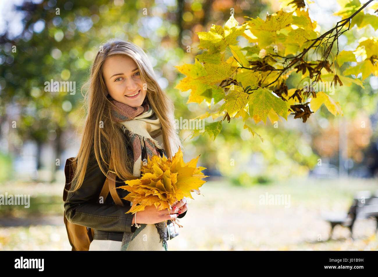 Autumn portrait of the nice girl. In her hands a bouquet of yellow ...