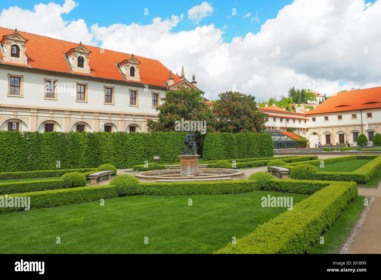 A fountain with a statue and blooming chestnut trees in Wallenstein Garden (Valdstejnska Zahrada), Prague, Czech Republic on a summer day. Stock Photo