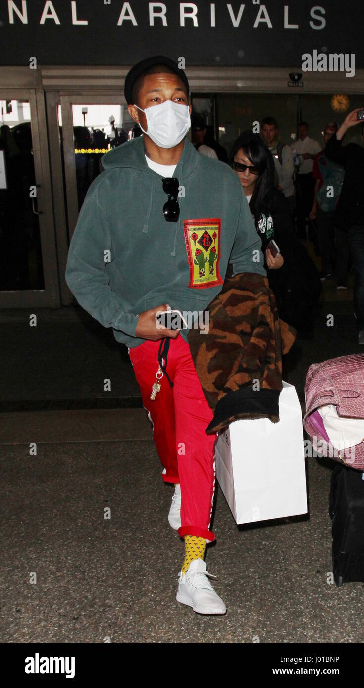 Pharrell Williams wears a surgical face mask as he arrives at Los ...