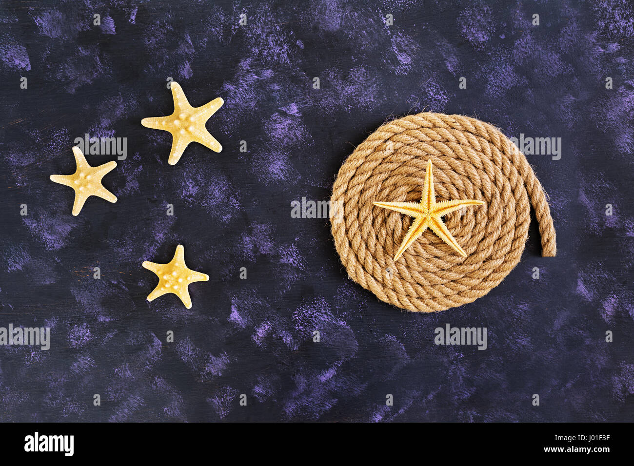 Rope and starfish on dark background. Top view Stock Photo - Alamy