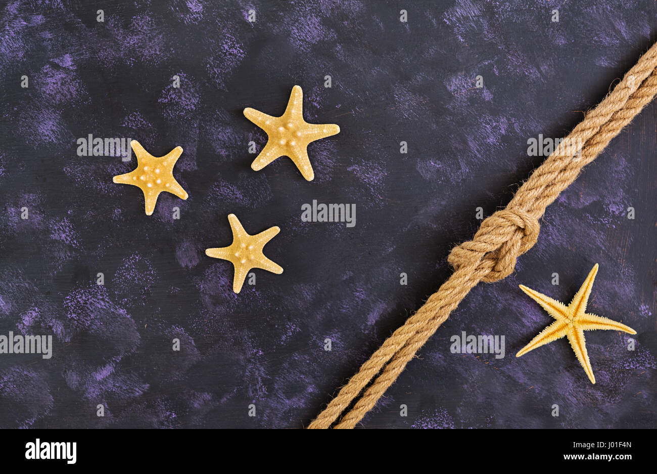 Rope and starfish on dark background. Top view Stock Photo - Alamy