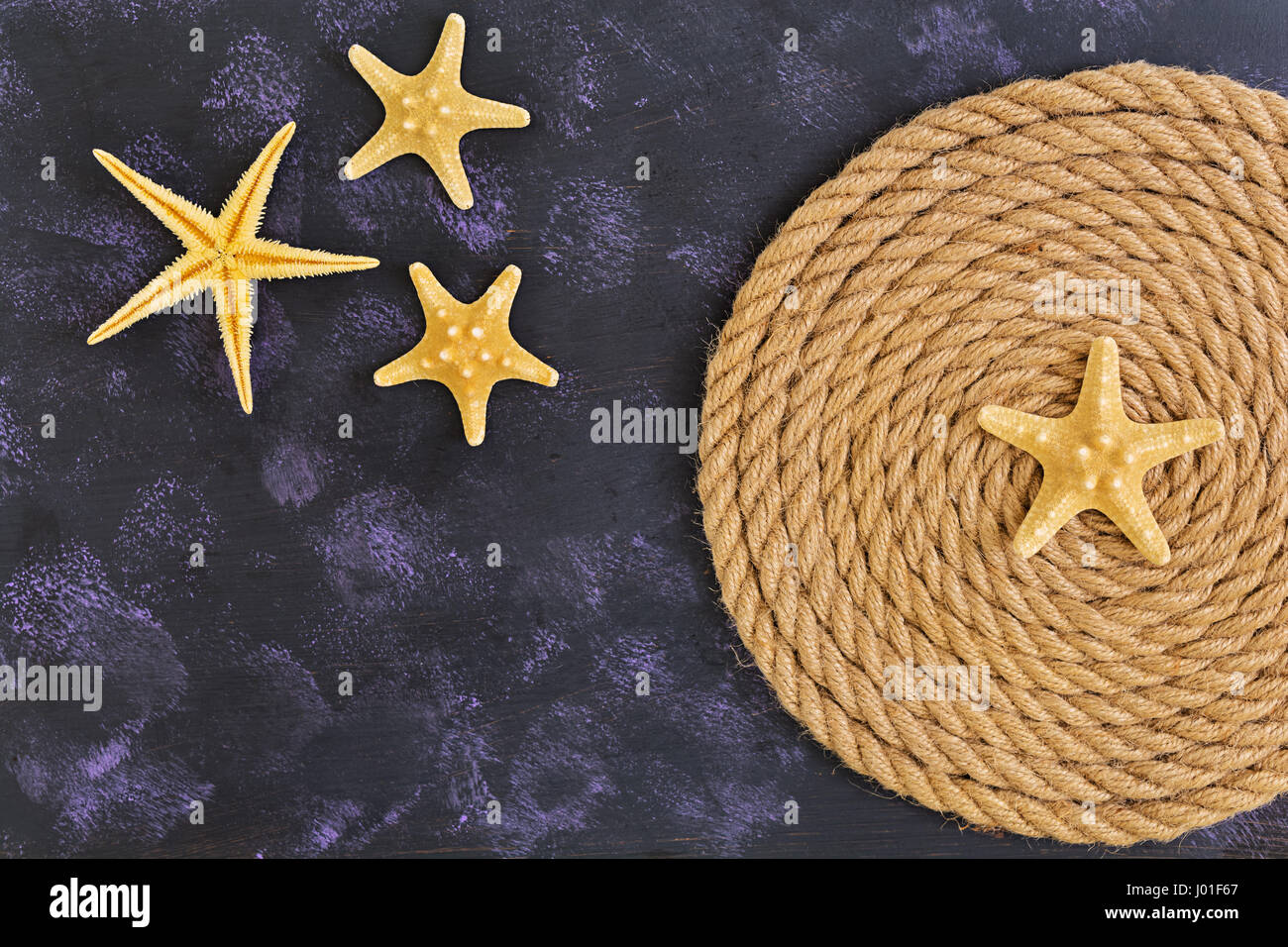 Rope and starfish on dark background. Top view Stock Photo - Alamy