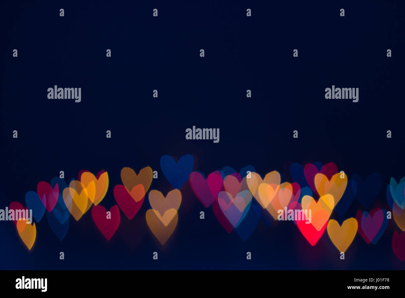 Heart shape lights line on dark blue background Stock Photo - Alamy