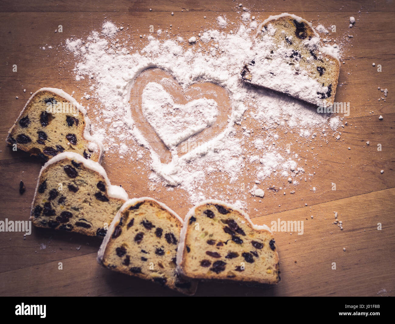 Stollen, traditional German Christmas yeast cake with raisins on wooden