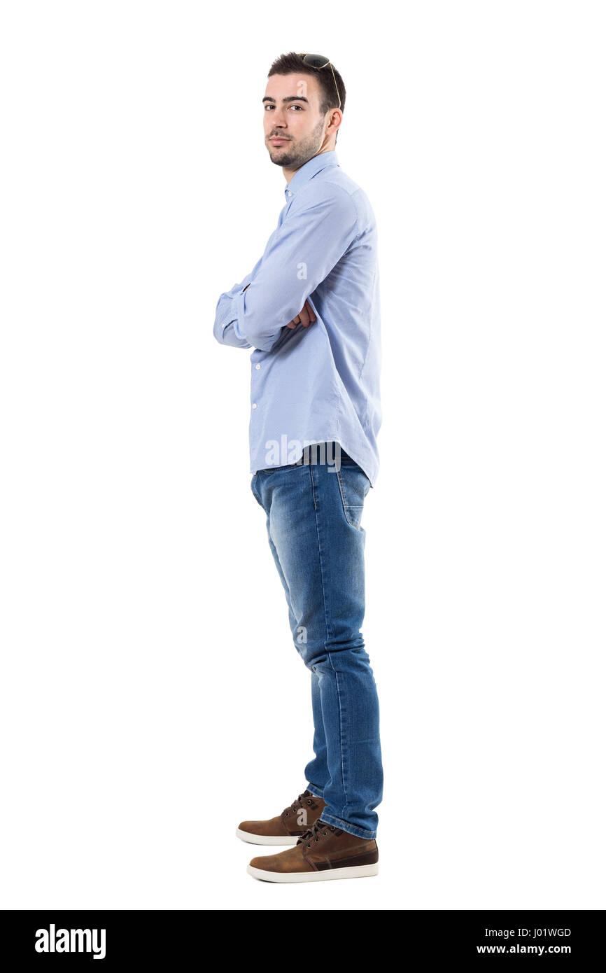 Side view of young confident businessman with crossed arms looking at ...