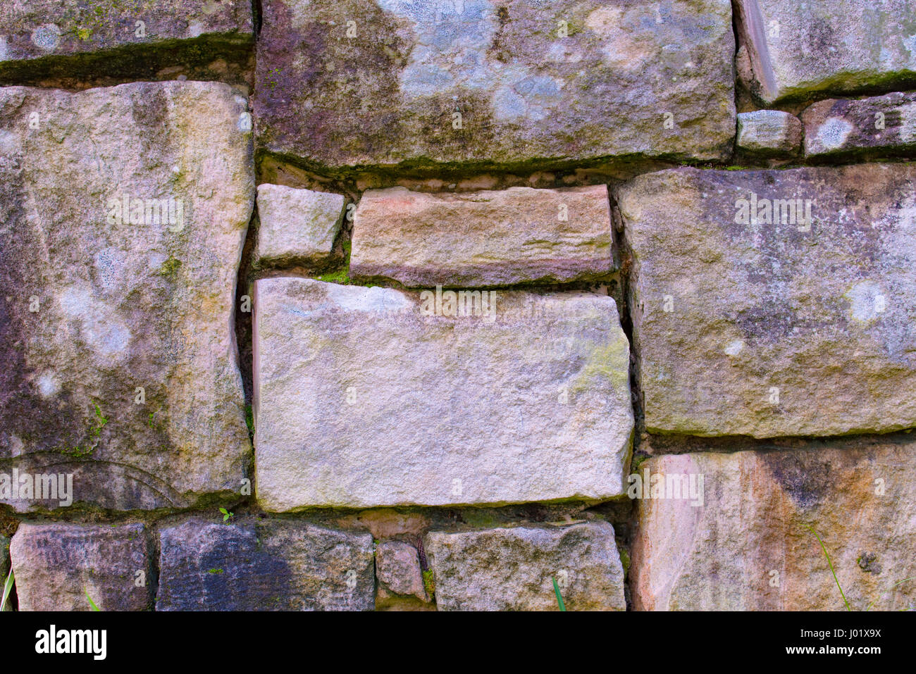 Natural Sydney sandstone cut into rectangular shapes in a retaining wall Stock Photo