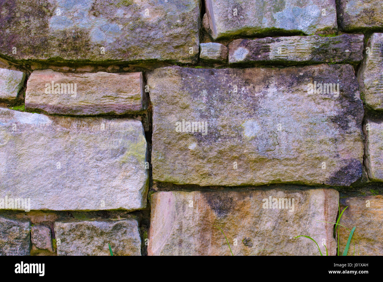 Natural Sydney sandstone cut into rectangular shapes in a retaining wall Stock Photo