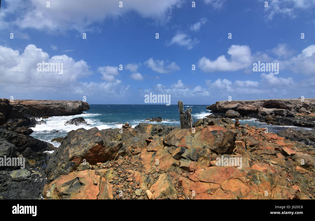 Rusty Reddis Beach Rocks Rusty jagged rocks in front of Aruba's black sand beach Stock Photo - Alamy