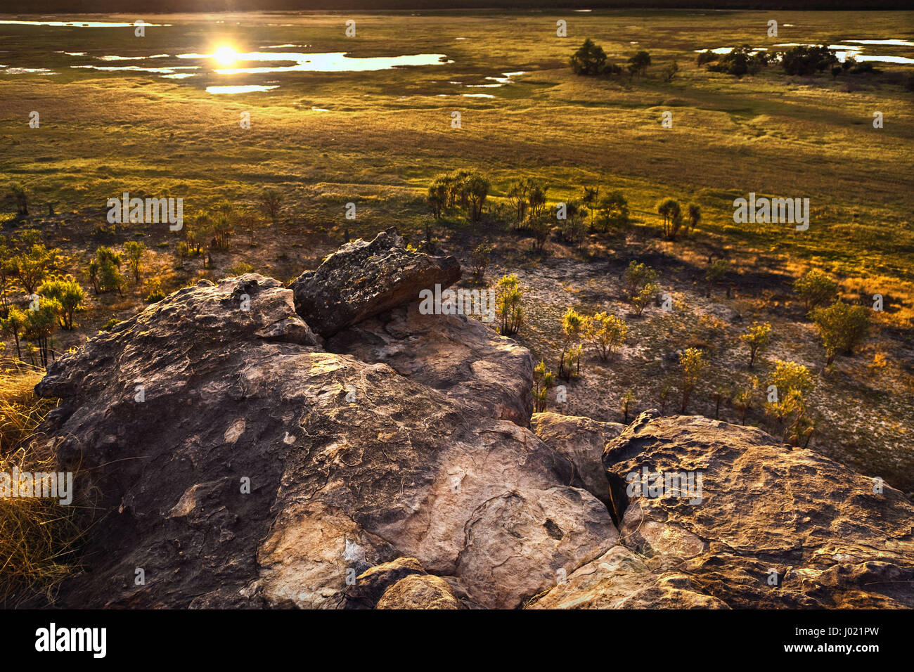 Dusk at Ubirr rock looking down at the sun reflected in the waters of the Nadab floodplains. Northern Territory, Australia Stock Photo