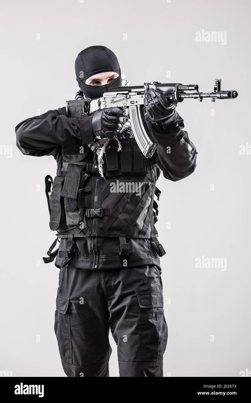 Terrorism concept: Terrorist holding a machine gun in his hands isolated over white Stock Photo