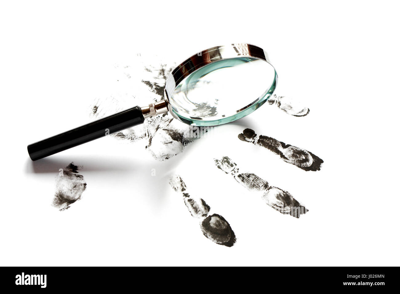 Crime concept. Black fingerprints and magnifying glass on white background Stock Photo