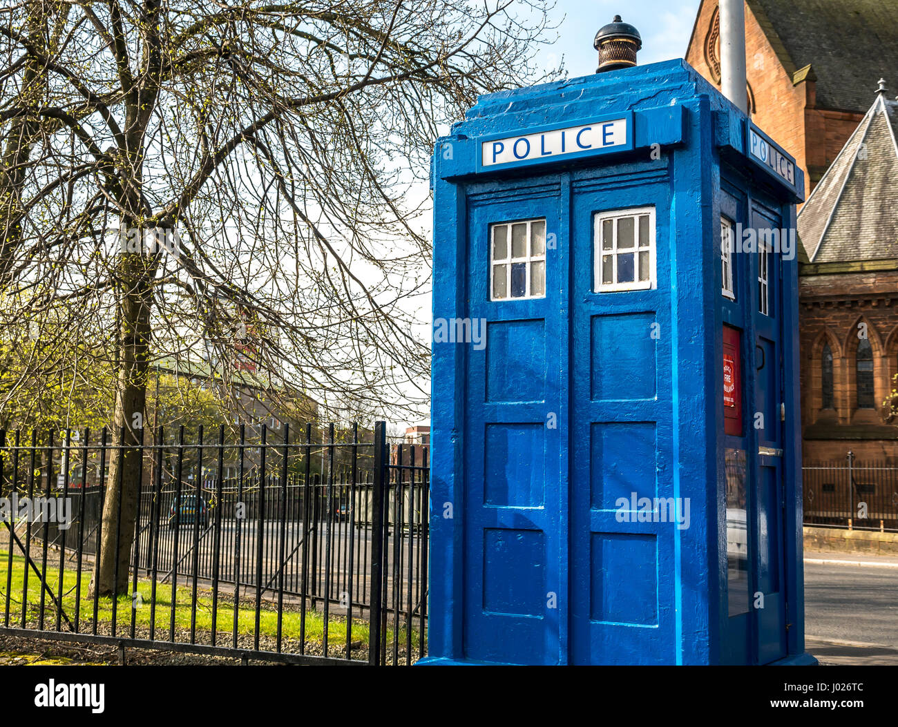 Old blue police box, Tardis, city centre street, Glasgow, Scotland, UK with red sandstone church in background, Scotland, UK Stock Photo
