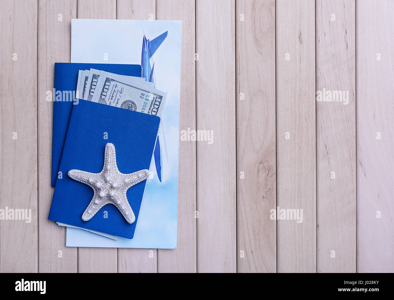 Passport and money and a plane ticket on wooden boards. Stock Photo