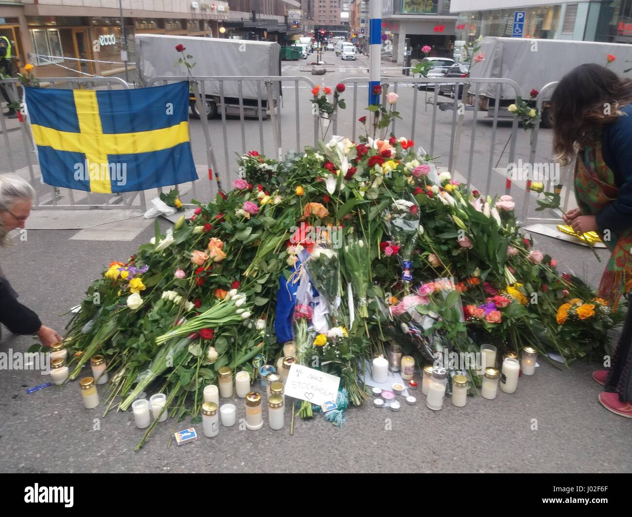 Piles of fresh flower bouquets, laid near the Ahlens shopping centre of Stockholm city(Drottninggatan str)  portraying the Swedish sympathy and sorrow for the lost lives of their compatriots, after a terrorist attacker driving a truck at high speed, slammed into pedestrians walking around the cityat  the time of the attack. Stock Photo