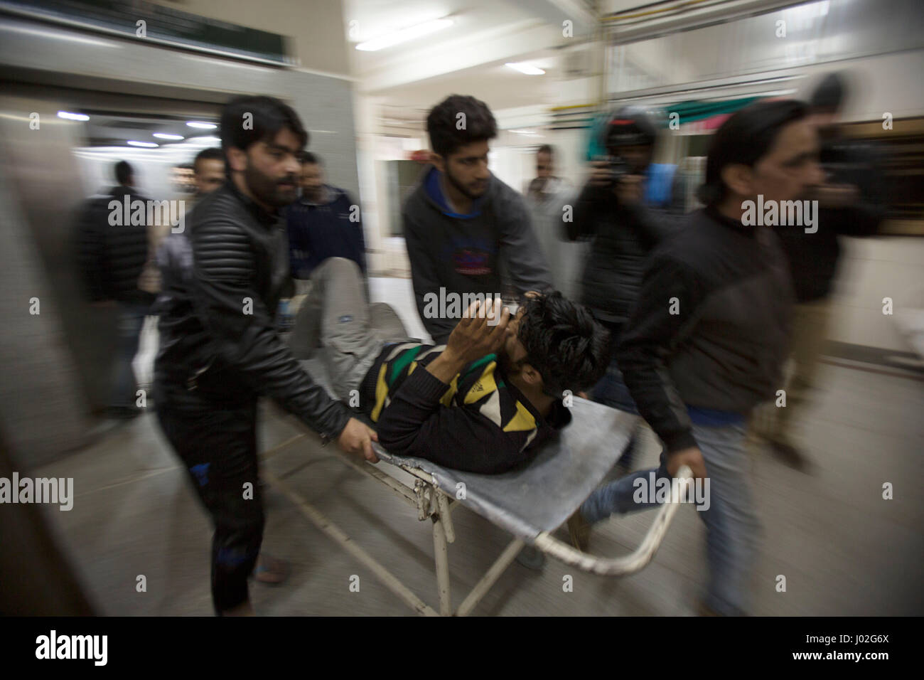Srinagar, Indian-controlled Kashmir. 9th Apr, 2017. People transfer a wounded person inside a hospital in Srinagar, summer capital of Indian-controlled Kashmir, April 9, 2017. At least three persons were killed and several others injured on Sunday when Indian security forces opened fire on a stone-pelting mob that stormed a polling station in Indian-controlled Kashmir's parliamentary constituency of Srinagar. Credit: Javed Dar/Xinhua/Alamy Live News Stock Photo