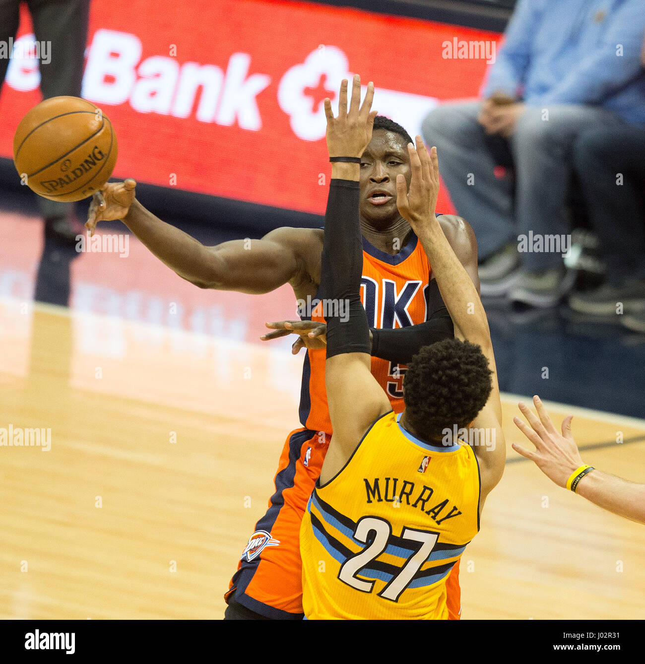 Denver, Colorado, USA. 9th Apr, 2017. Thunder's VICTOR OLADIPO, top, passes the ball past Nuggets JAMAL MURRAY, bottom, during the 1st. Half at the Pepsi Center Sunday afternoon. The Thunder beats the Nuggets 106-105. Credit: Hector Acevedo/ZUMA Wire/Alamy Live News Stock Photo