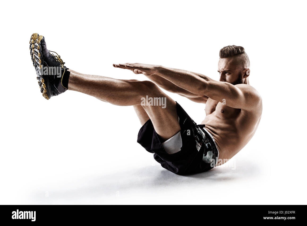 Handsome young man doing fitness exercise. Photo of muscular man in silhouette on white background.  Fitness and healthy lifestyle concept Stock Photo