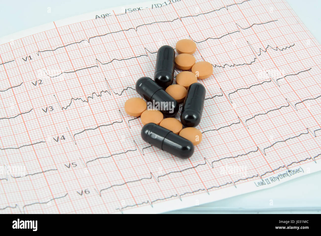 Medical pills and Electrocardiogram. ECG tape and pills. Stock Photo