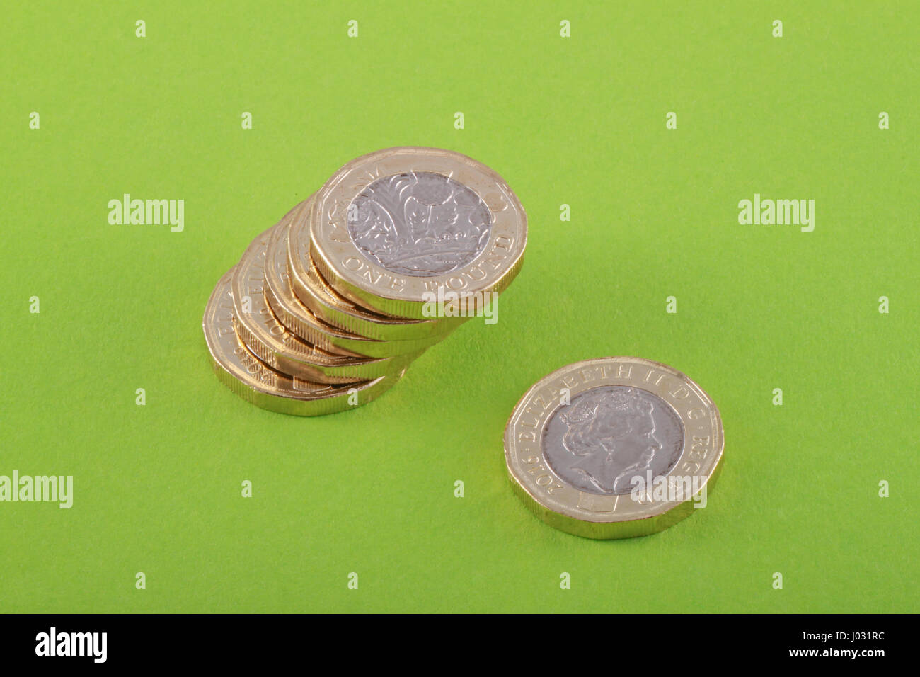 New British, UK one pound coins on a green background. It was released into circulation on March 28 2017. Stock Photo