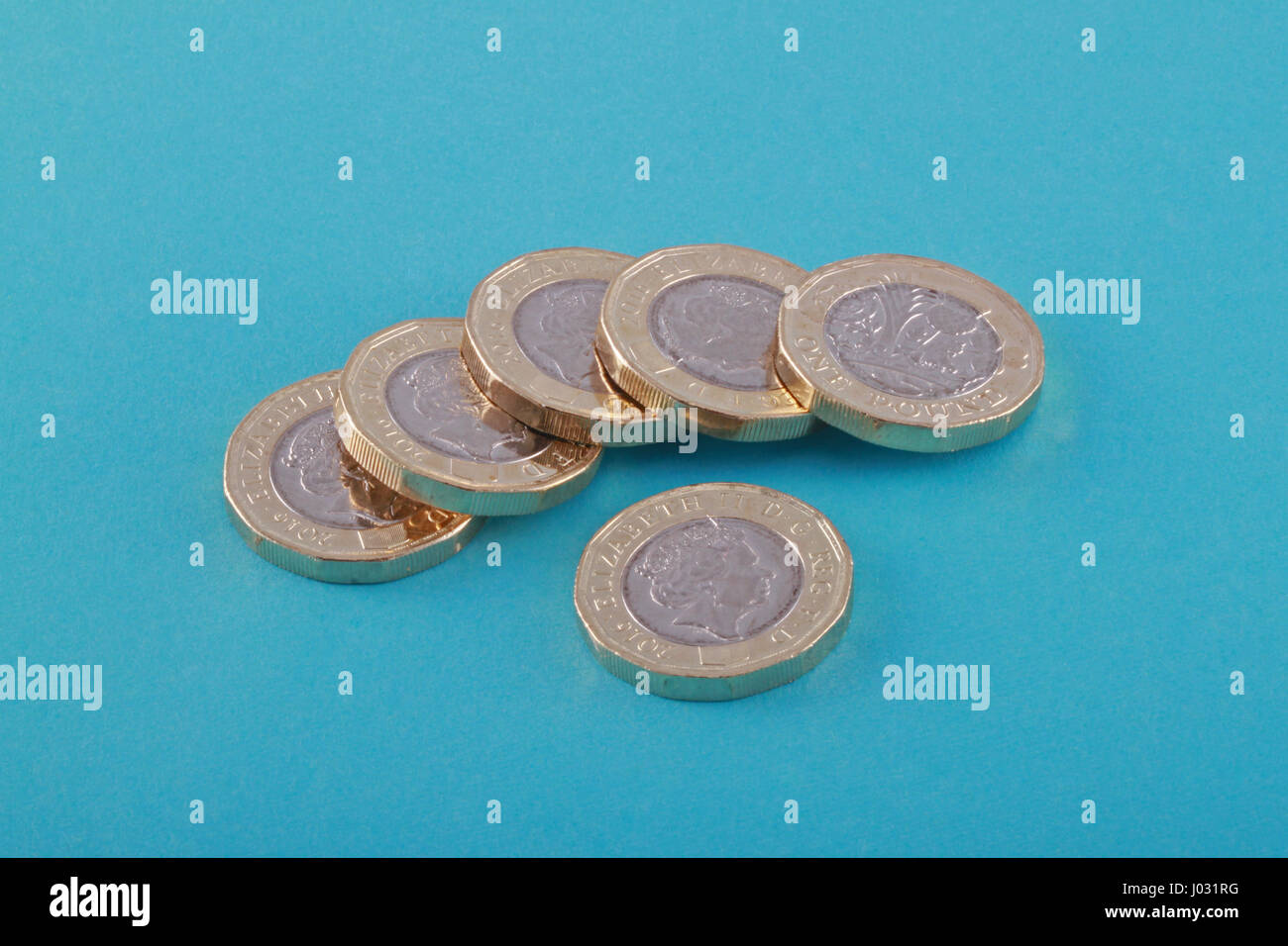 New British, UK one pound coins on a blue background. It was released into circulation on March 28 2017. Stock Photo