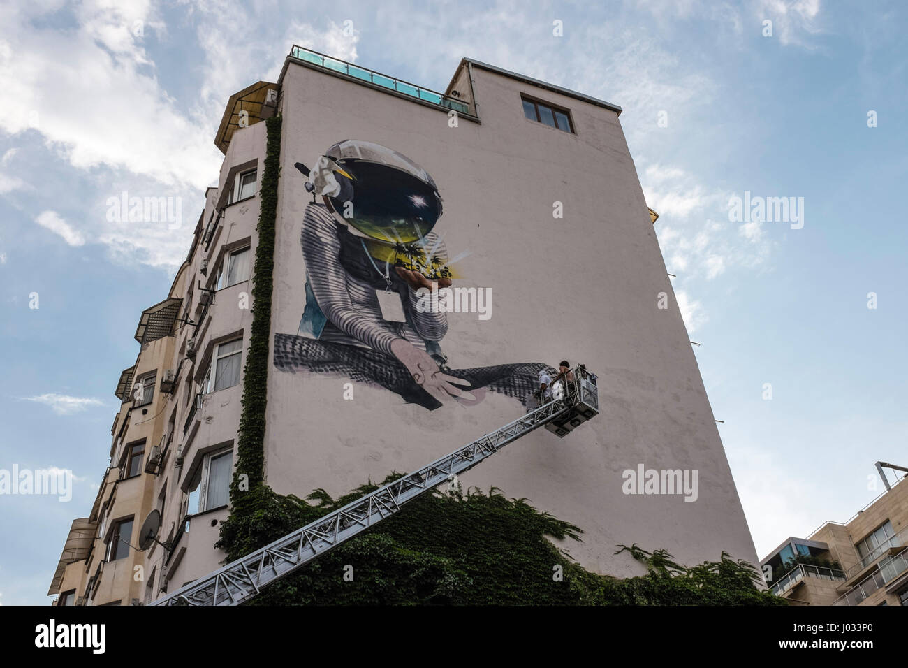 Street art graffiti being painted on apartment building in Tbilisi, Georgia, Eastern Europe Stock Photo