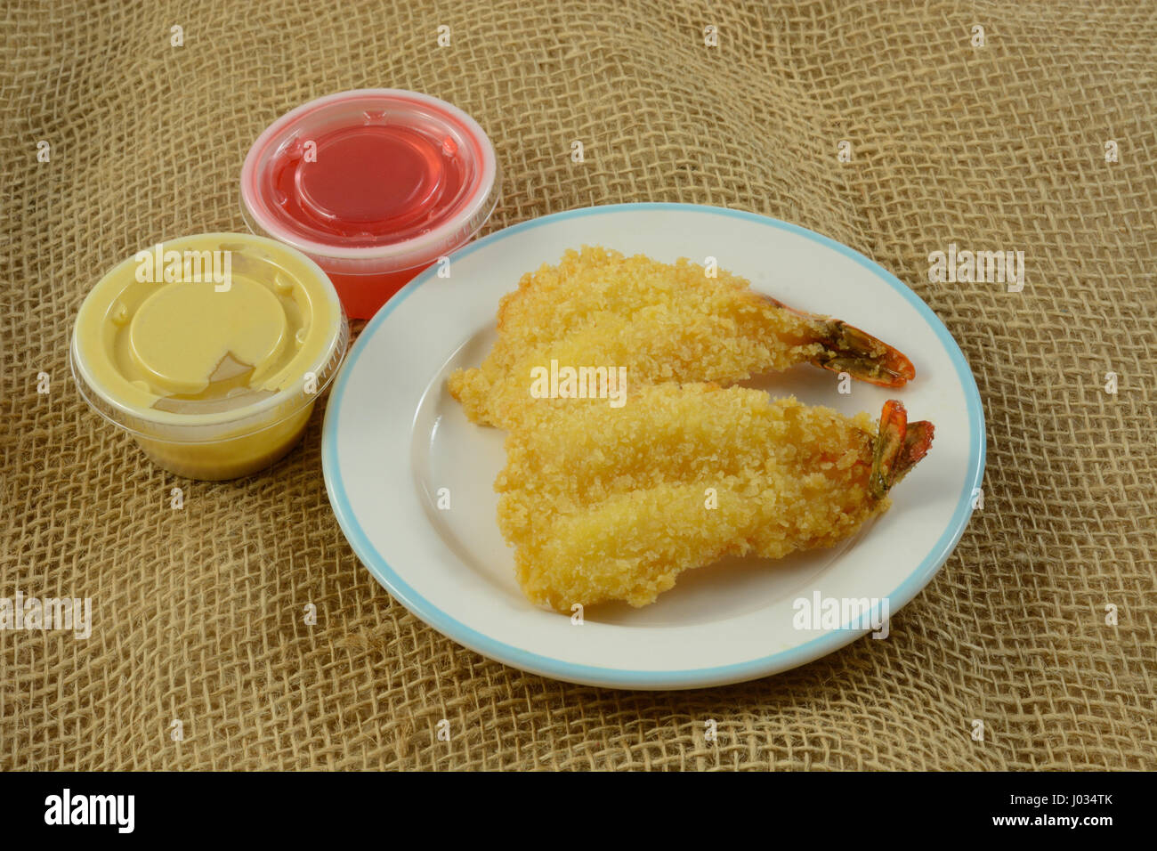 Chinese food appetizer of fried fantail shrimp with small containers of