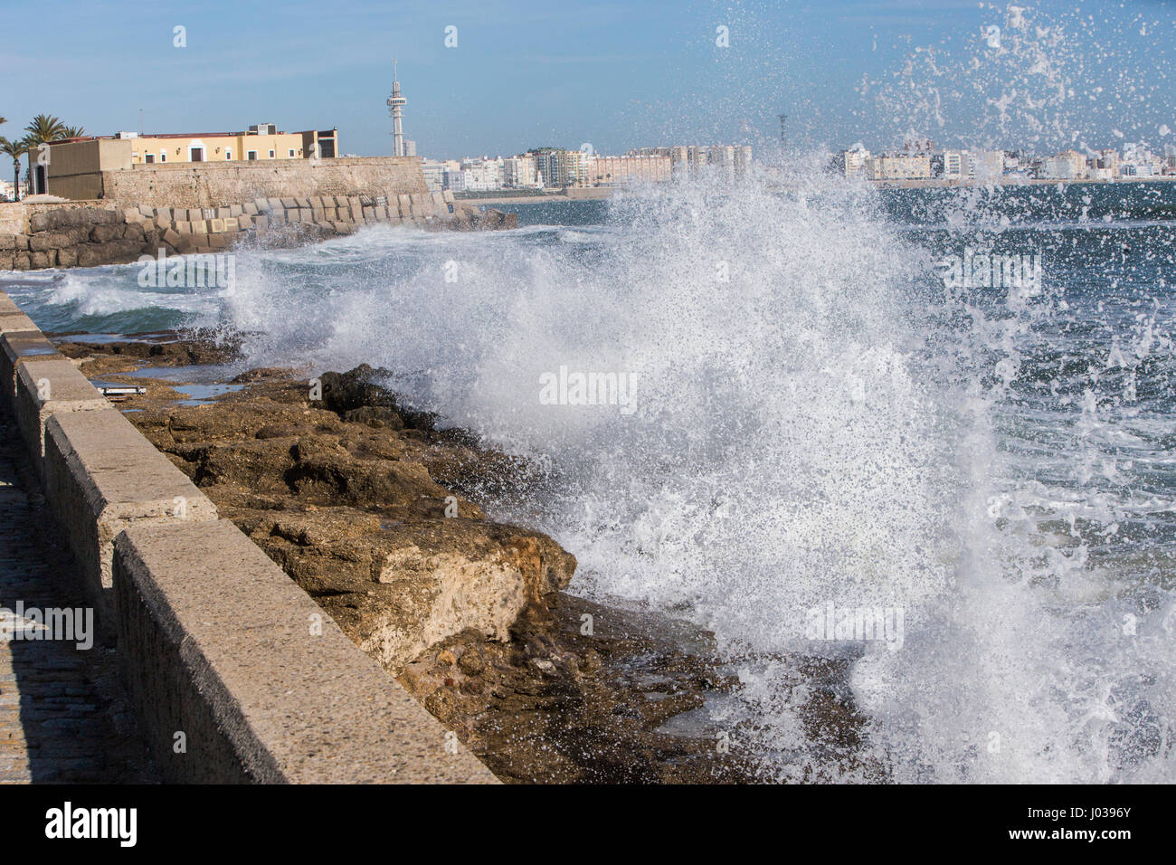 Waves hit the rocks on the promenade of the La Caleta beach in Cadiz, Spain Stock Photo