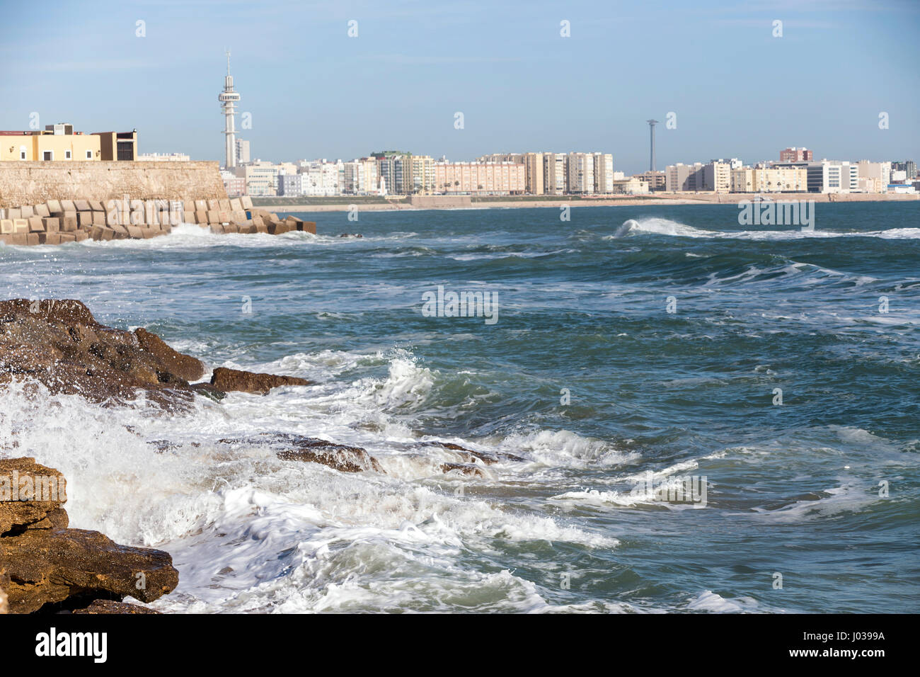 Waves hit the rocks on the promenade of the La Caleta beach in Cadiz, Spain Stock Photo