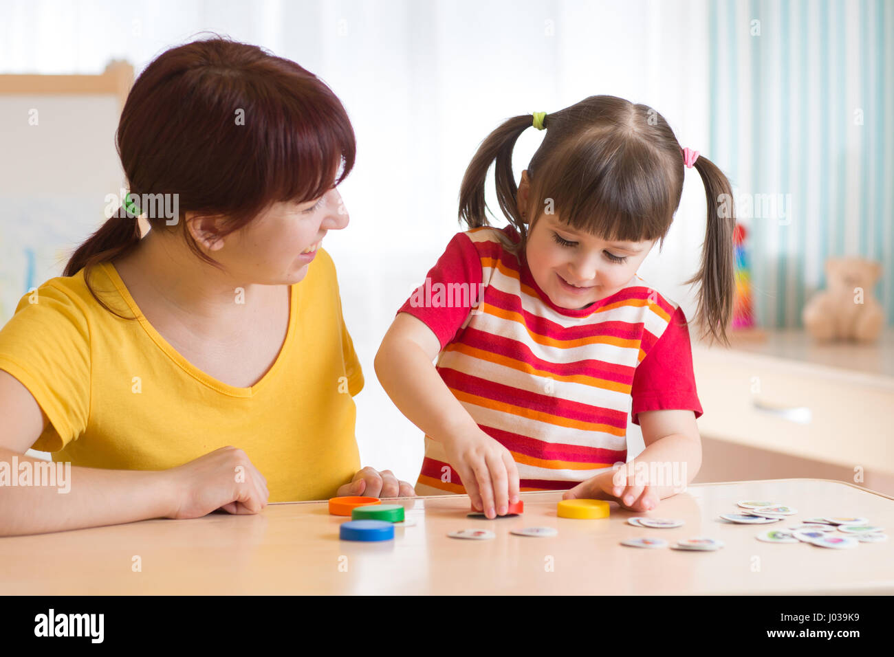 Young woman plays with kid educational game Stock Photo