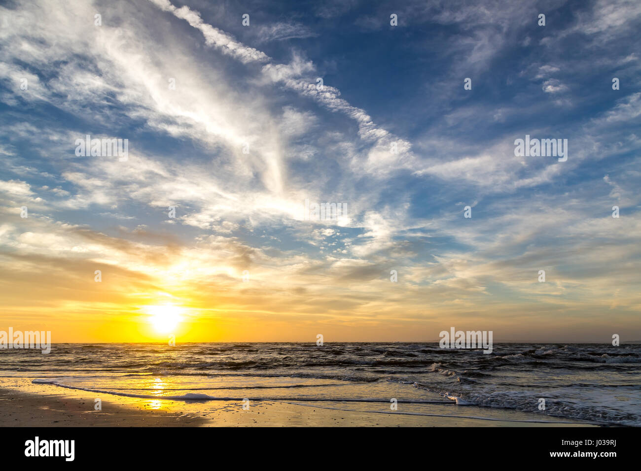 The sun rises at the beach on a cloudy morning over Amelia Island, Florida. Stock Photo