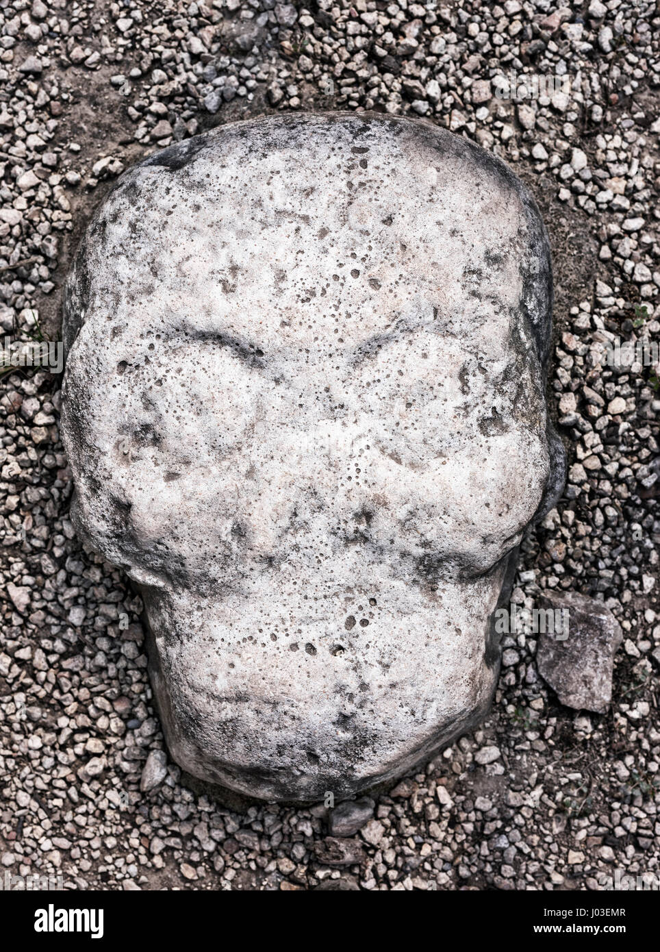 ancient skull stone sculpture embedded in ground of the ball court at
