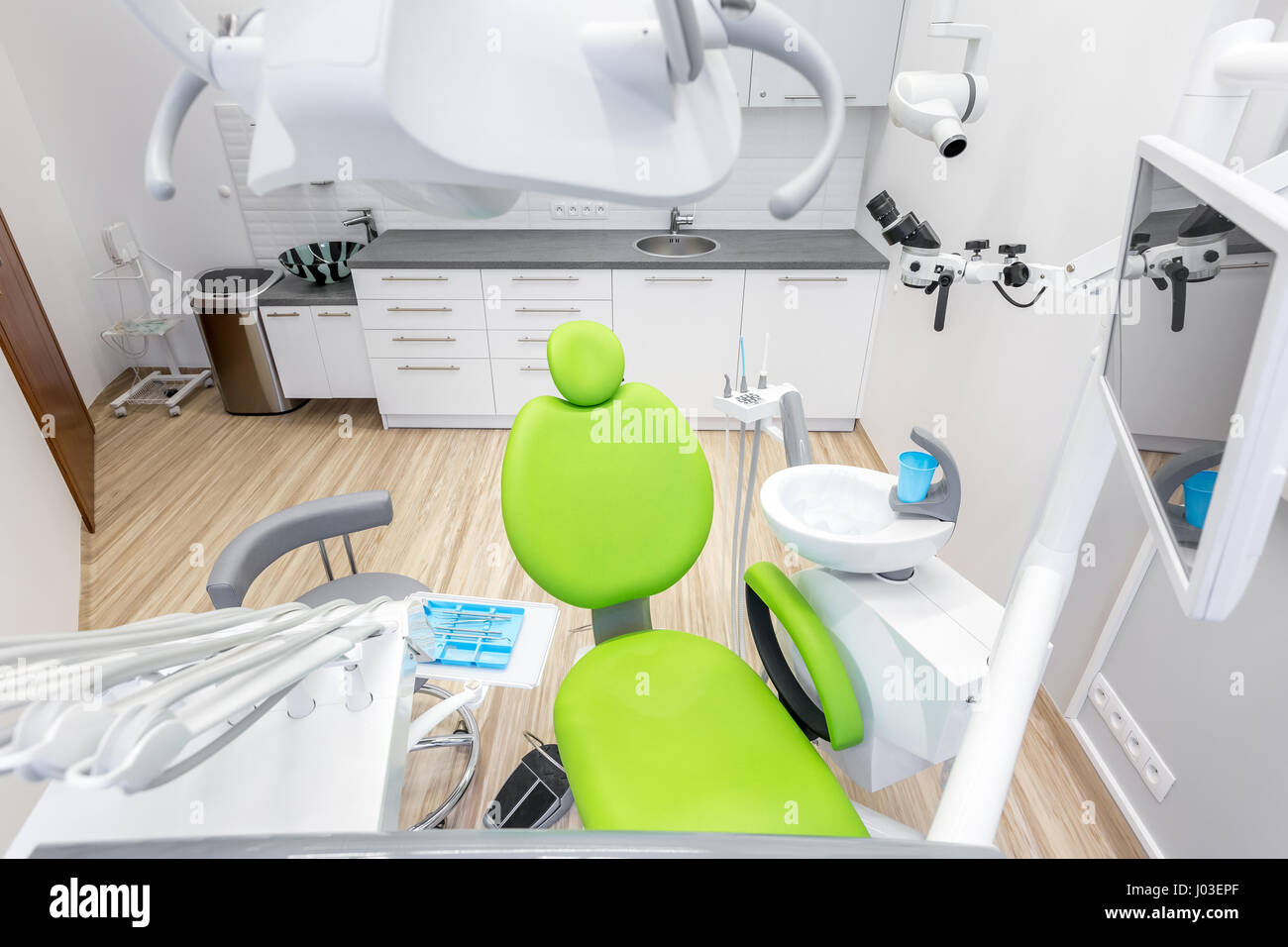 Modern dental office with green chair and professional computer