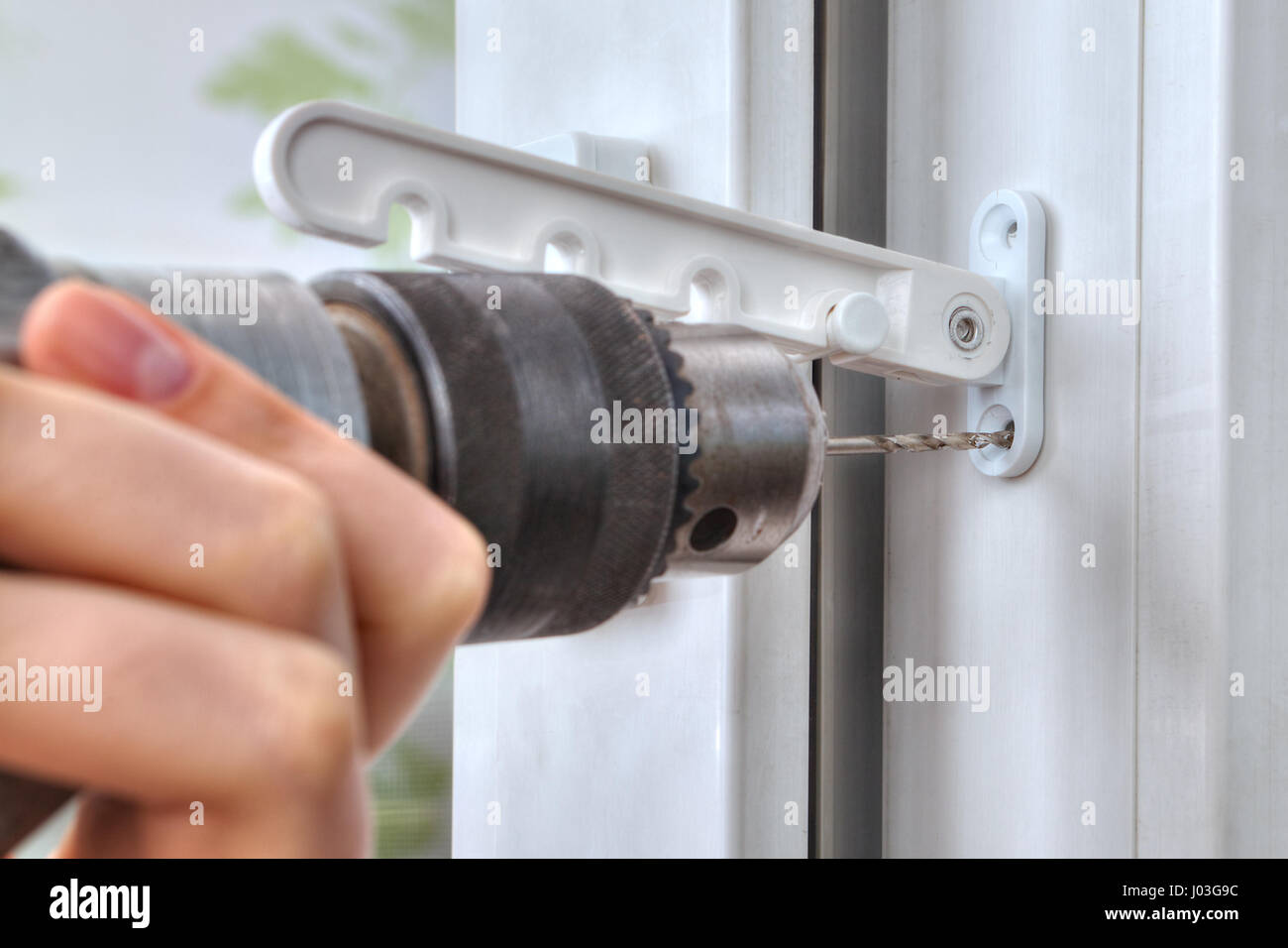 Drilling holes for fasteners to install the window limiter, close-up ...