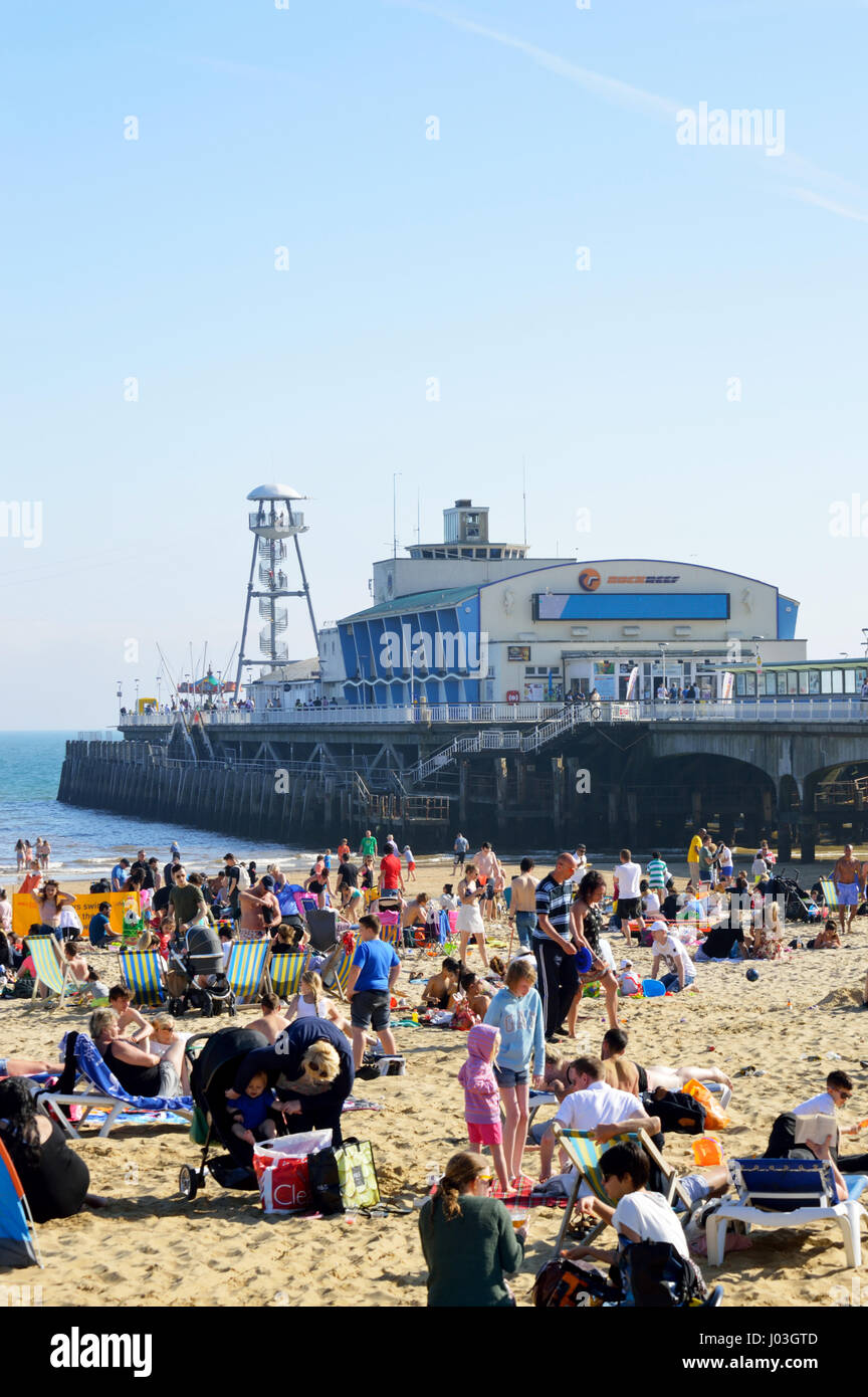 People sunbathing at crowded Bournemouth Beach with Bournemouth Pier in the background in 2017, Dorset, UK Stock Photo