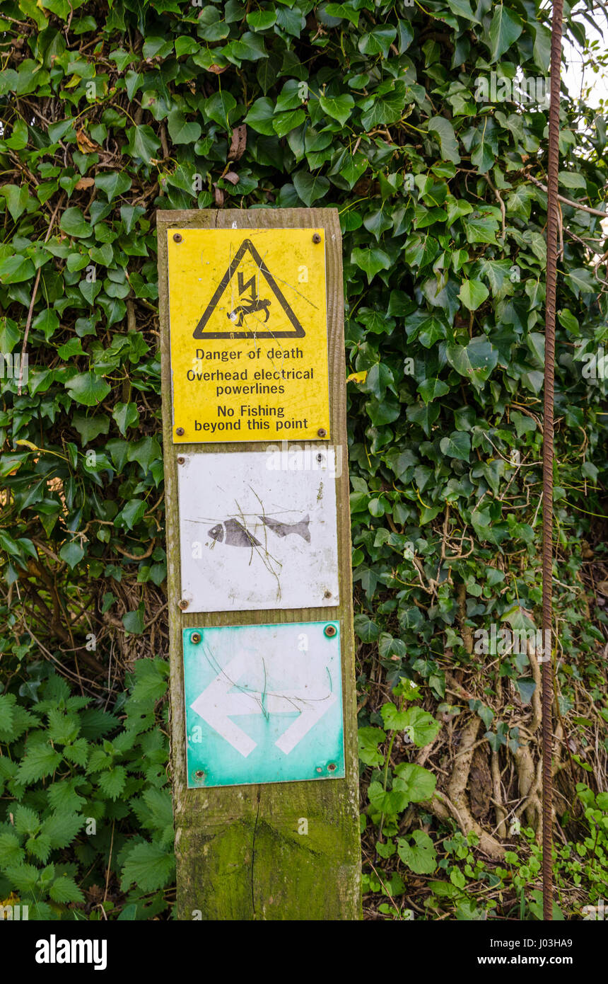 A sign next to the River Kennet in Reading indicating that no fishing is allowed due to overhead power cables. Stock Photo