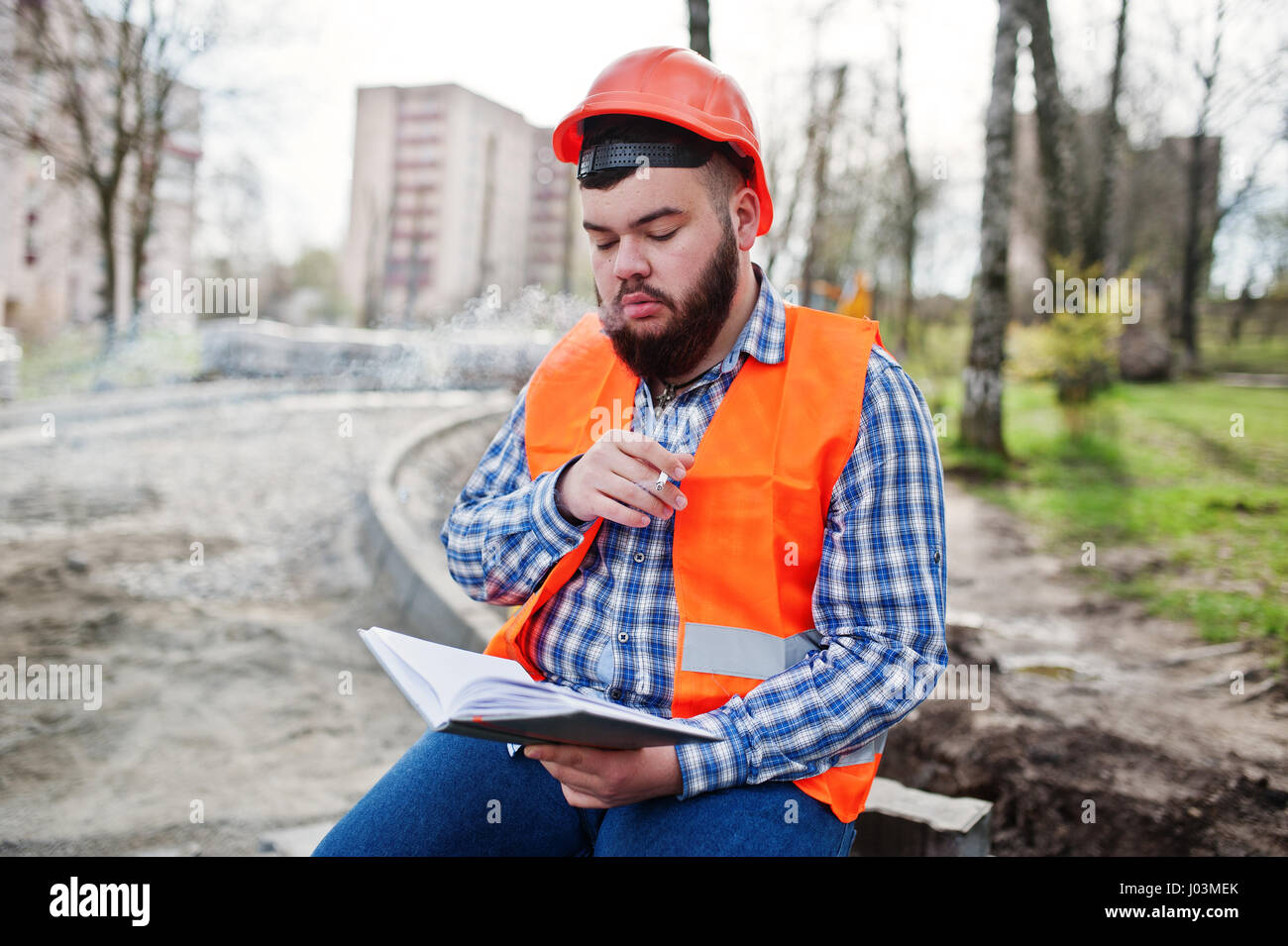 Brutal beard smoking worker man suit construction worker in safety